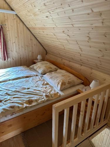 a bed in a room with a wooden ceiling at Chata v údolí in Rozbehy