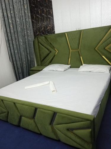a bed in a room with a green headboard at AL Imran VILLA in Lahore