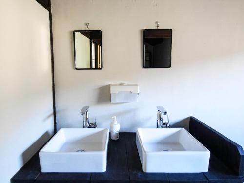 a bathroom with two sinks and two mirrors at HakoneHOSTEL1914 in Hakone