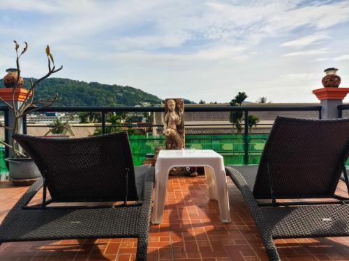 een klein beeldje zittend op een tafel op een balkon bij Kata Lina rooftop in Kata Beach