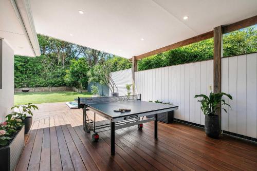 a ping pong table sitting on a patio with at Forresters Lodge by Coast Hosting in Wamberal North