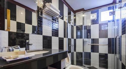 a bathroom with a sink and a shower and a toilet at The Mou Hotel in Phnom Penh