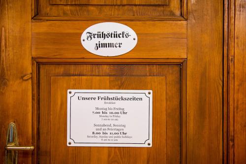 a sign on a wooden door with a sign on it at Jahrhunderthotel Leipzig in Leipzig