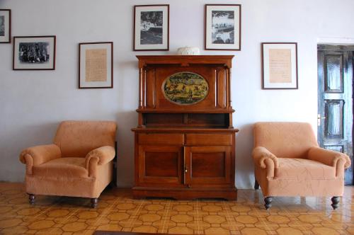 a room with a grandfather clock and two chairs at Tree of Life Grand Oak Manor Binsar in Binsar