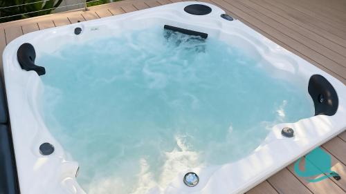 a bath tub sitting on top of a wooden deck at Village Bay Lake house family Lake House with Spa in Marks Point