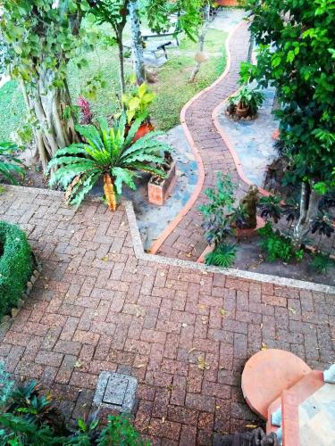 a brick walkway in a garden with plants at Mut Mee Garden Guest House in Nong Khai