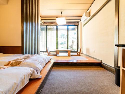 a bedroom with two beds and a table at Kirishima Momijidani Seiryuso - Vacation STAY 63056v in Kirishima