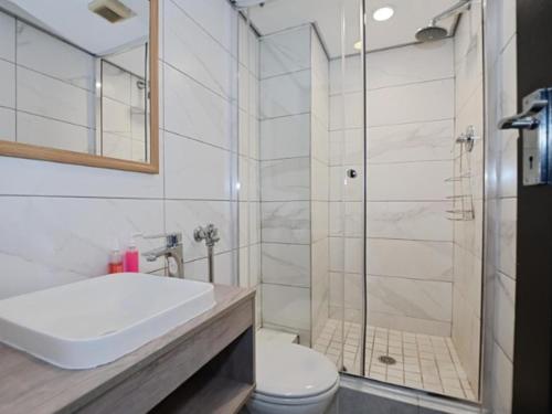 a bathroom with a shower and a toilet and a sink at Blouberg, Nautica and Studio Apartments in Cape Town