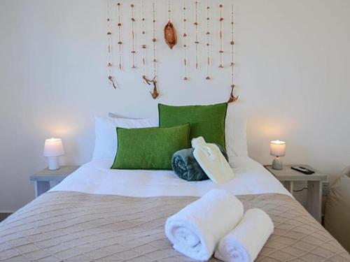 a bedroom with a bed with two towels on it at Blouberg, Nautica and Studio Apartments in Cape Town