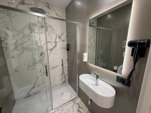 a bathroom with a shower and a sink and a mirror at Maison Rasella Palace Suites in Rome