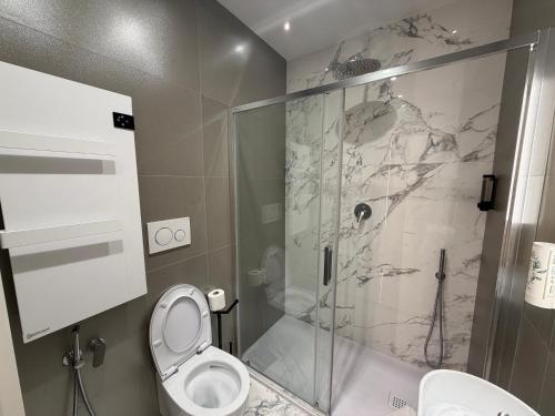 a bathroom with a toilet and a glass shower at Maison Rasella Palace Suites in Rome