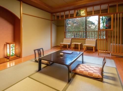 a living room with a wooden table and chairs at Katakurinohana in Senboku