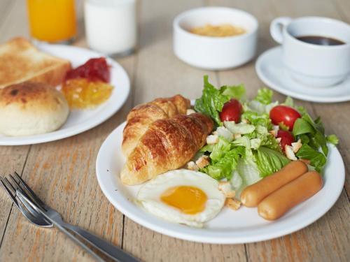 een bord ontbijtproducten met een ei en een salade bij Bangkok City Hotel in Bangkok