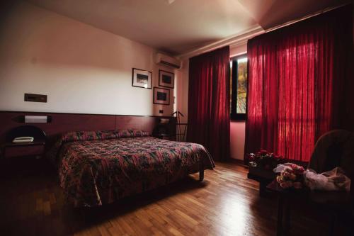 カイロ・モンテノッテにあるHotel Cityのベッドルーム(ベッド1台、赤いカーテン付)