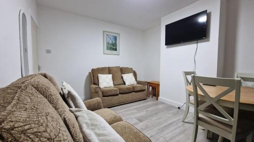 a living room with a couch and a table and a television at Nice Living Serviced Accommodations Birmingham 2 in Birmingham