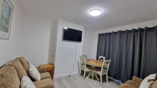 a living room with a couch and a table with chairs at Nice Living Serviced Accommodations Birmingham 2 in Birmingham