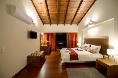 a bedroom with a large bed with a wooden ceiling at Althea Apartments in Katakolon