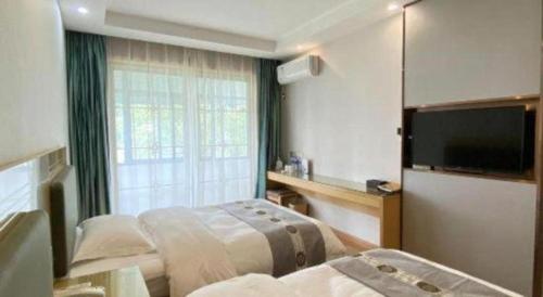 una habitación de hotel con dos camas y un televisor de pantalla plana en Shell Hefei Luyang District Sipai Building Subway Station Hotel, en Hefei