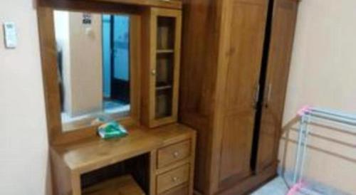 drewniana komoda z lustrem na górze w obiekcie Algira Homestay Prambanan w mieście Prambanan