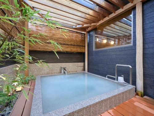 a hot tub in the backyard of a house at Business Hotel Wayoukan in Inazawa