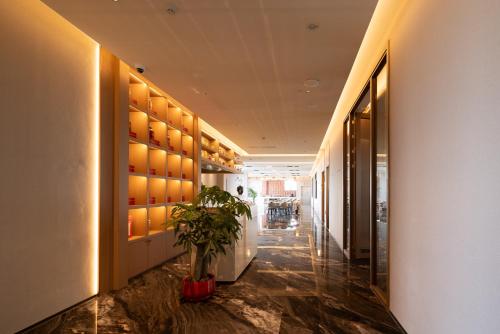 a hallway with a potted plant in a building at Oriental Elegant Hotel in Libeiling