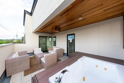 a room with a bath tub and a living room at Kotohaku 木津町 in Kizugawa