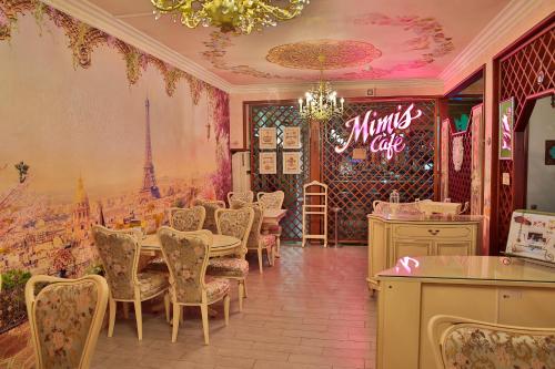a restaurant with a dining room with a table and chairs at Amsterdam Hotel Aktobe in Aktobe