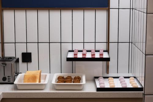 长沙Changsha Huanman Hotel Huanghua Airport Yong'an Branch的厨房柜台上放着三盘糕点。