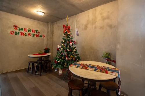 a room with two tables and a christmas tree at Kenny Hill Boutique Hotel near Borneo Medical Centre Kuching in Kuching