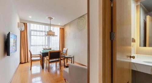 a kitchen and dining room with a table and chairs at GreenTree Inn Suzhou Changshu North Haiyu Road Changhui Square Express Hotel in Changshu