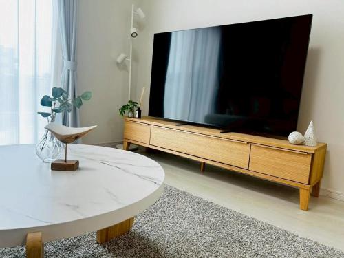 een woonkamer met een grote flatscreen-tv bij 馥の森 in Kumamoto