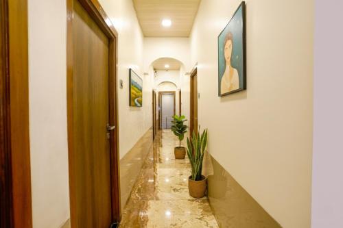 孟买FabExpress Malali Residency的走廊上,地板上种植了两株盆栽植物