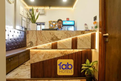孟买FabExpress Malali Residency的一名男子坐在酒店大堂的柜台前