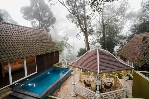 een huis met een zwembad en een prieel bij Kings Holidays Munnar in Ūdumbanshola