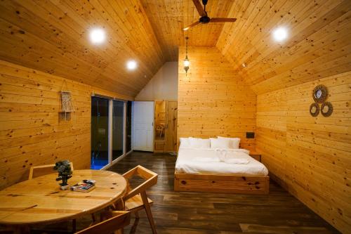 een kamer met een bed en een tafel. bij Kings Holidays Munnar in Ūdumbanshola