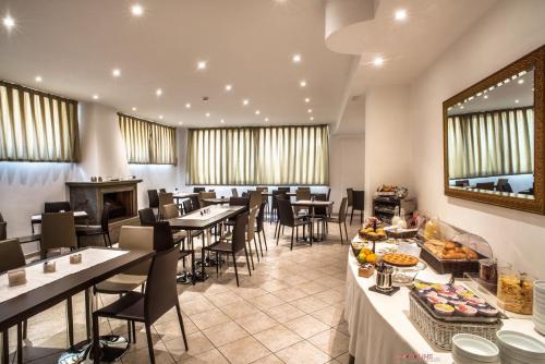 una grande sala da pranzo con tavoli e sedie di Hotel Villa Giulia a Ciampino
