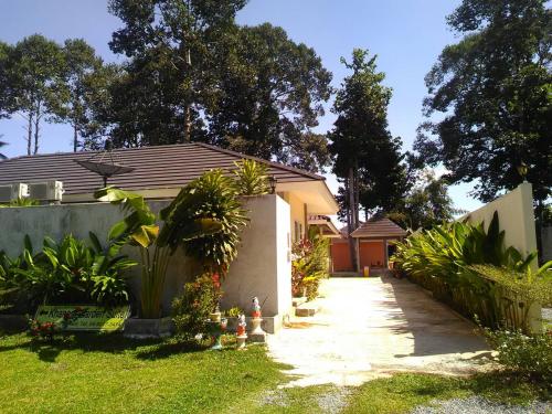 a garden with a house and a sidewalk at Khanom Garden Suite in Khanom
