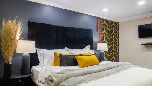 ein Schlafzimmer mit einem großen Bett mit gelben Kissen in der Unterkunft EGB Guest House in Springs