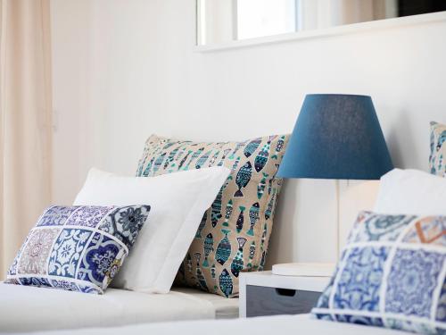 a bed with blue and white pillows and a lamp at Marino Lisboa Boutique Guest House in Lisbon