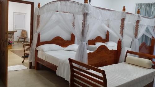 a bedroom with two beds with white drapes at Tea Hills Bungalow in Hatton