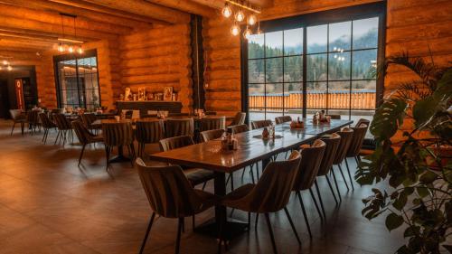 ein Esszimmer mit einem langen Tisch und Stühlen in der Unterkunft Hanul și Păstrăvăria Țibău in Cîrlibaba