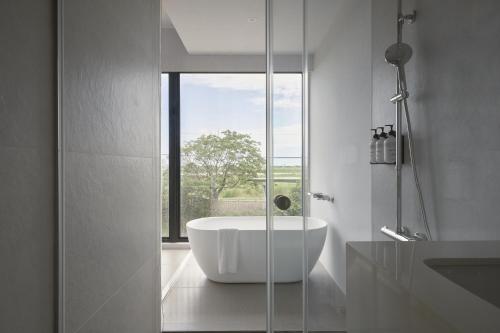 Un baño con bañera y ventana. en 澤木行旅 The Riverwood, en Yilan City
