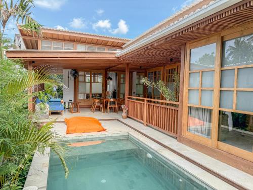 Japanese Villa في كوتا لومبوك: منزل مع حوض سباحة أمامه