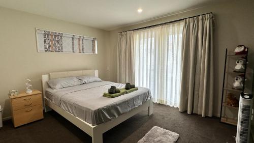 a bedroom with a bed and a large window at City Fringe-Guest House in Christchurch