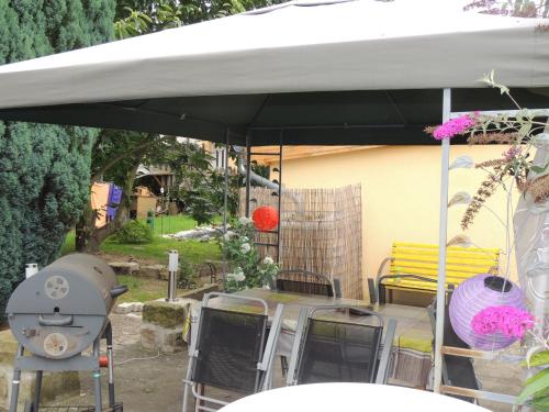 a group of tables and chairs under a white umbrella at Ferienwohnungen am Hauptplatz in Pirna