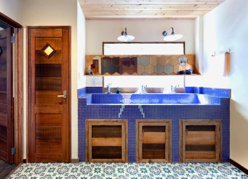 bagno con lavabo e bancone con piastrelle blu di The Pax Hostel ad Osaka
