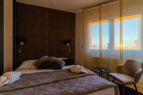 NAR Royalton Deluxe Apartment #74 في نيشْ: غرفة نوم بها سرير وكرسي ونافذة