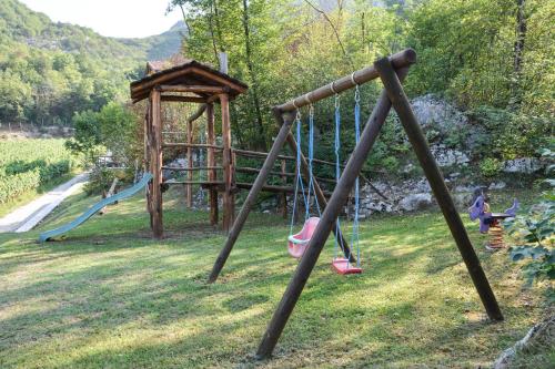 a playground with swings and a gazebo at Maso Salim Relax Apartments in Drena