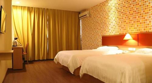 ein Hotelzimmer mit zwei Betten und einer Ziegelwand in der Unterkunft 7 Days Inn Zhenjiang Jiangsu University in Tan-t'u-chen