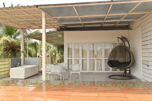 un patio con una vasca, una sedia e un'altalena di Casa Swarg a Parra